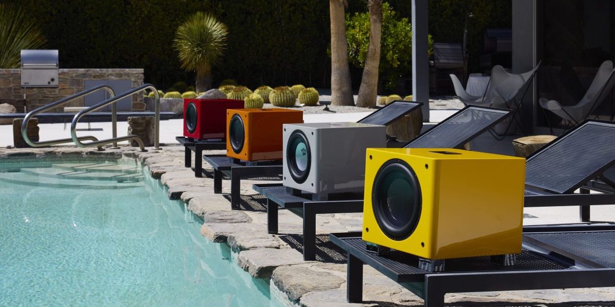 A picture of a poolside with a range of REL Acoustics subwoofers along its edge